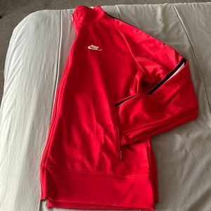 Red Nike tech jacket pants are sold separately